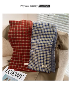 Detail of plaid knit scarves in red and blue tones on a cozy autumn background