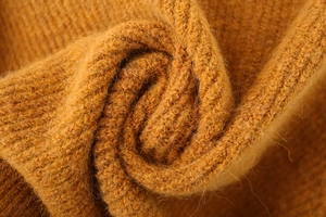 Close-up of mustard yellow rib-knit fabric with soft mohair texture and warm fibers