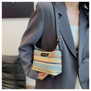 Detail of colorful striped woven shoulder bag worn underarm with fashion leather tag