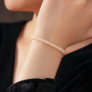 Elegant gold woven mesh bangle with sparkling zircon accents on a model's wrist