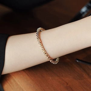 Minimalist gold geometric open bangle with crushed metal texture on woman wrist