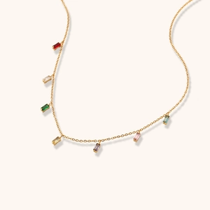 Detail of gold necklace featuring seven colorful rectangular zircon stones on fine chain