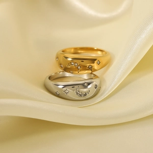 Minimalist 18k gold and silver star moon rings with zircon on beige silk background
