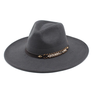 Detail of dark grey fedora hat featuring woven leather band with gold rivets