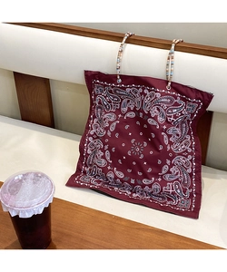 Detail of burgundy paisley tote bag with colorful braided rope handle and vintage pattern