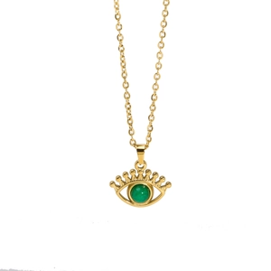 Detail of gold evil eye necklace with green gemstone pendant on white background