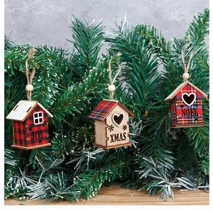 Detail of wooden Christmas house ornaments with XMAS and JOY text hanging on pine branches