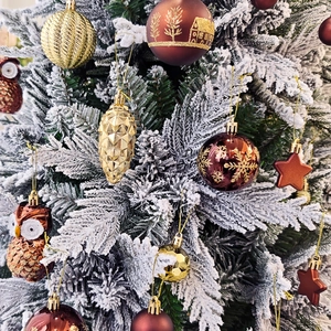 Vue détaillée d'ornements de Noël dorés et marron avec texture scintillante sur sapin