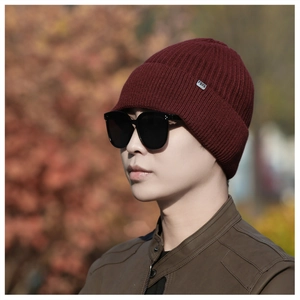 Detailed knit texture of burgundy winter beanie for men with metallic brand tag