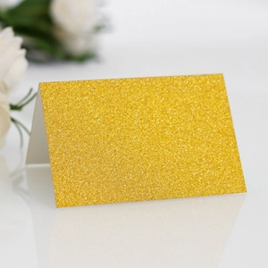 Detailed view of elegant gold glitter folded place card for wedding table seating