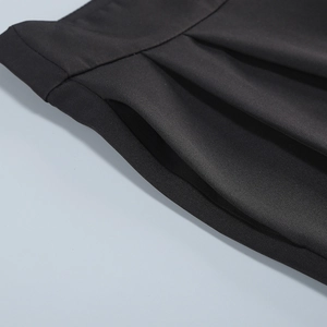 Detail shot of black slim-fit suit trousers featuring pocket seams and premium fabric