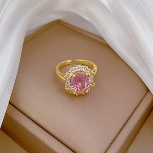 Detail of pink oval gemstone ring with pavé halo and adjustable gold band