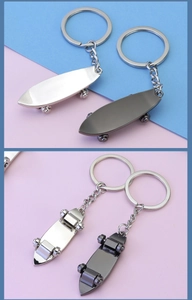 Detailed close-up of mini metal skateboard keychains in silver and gun-black finish