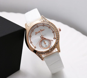 Close-up of rose gold watch case with crystal bezel and white crocodile leather strap