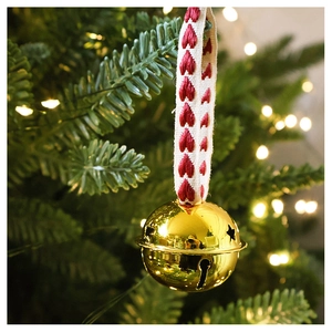Macro shot of a champagne gold star cutout bell with red heart fabric ribbon on tree