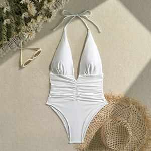 Detailed flat lay of white halter one-piece swimsuit with deep V-neck and ruched waist details