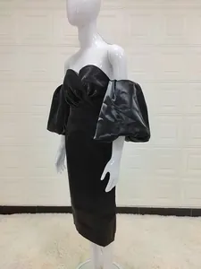 Detail of sweetheart neckline and oversized puff sleeves on black satin midi dress
