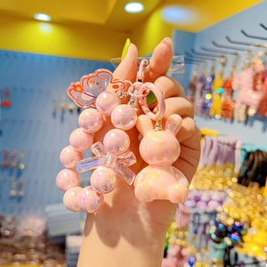 Detailed close-up of a pink beaded keychain with a cute rabbit doll and bow charm
