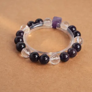 Bracelet en perles d'améthyste violette et cubes de cristal blanc sur fond marron