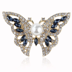 Elegant butterfly brooch with blue gems, small crystals and a center pearl on gold base