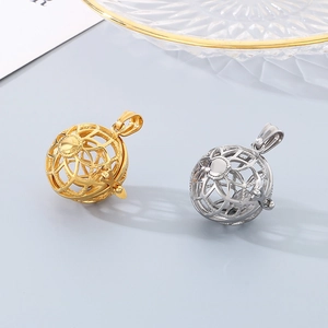 Golden and silver hollow flower sphere pendants in a minimalist studio setting