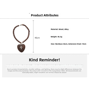 Détail d'un collier en perles de bois avec pendentif cœur et petite croix en métal