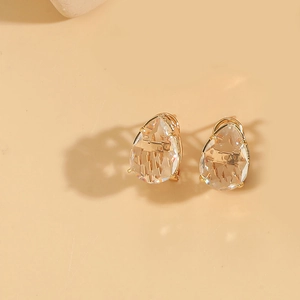 Macro detail of teardrop faceted crystal earrings with elegant gold plated settings