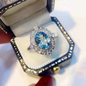 Bague fleur en zircon bleu ovale de luxe avec halo étincelant dans son écrin chic