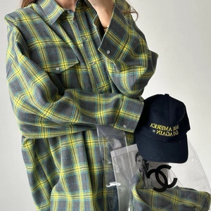Détail d'une chemise en flanelle à carreaux jaunes avec poches à rabat et boutons