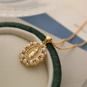 Gold plated Virgin Mary pendant necklace with pearl border on green velvet