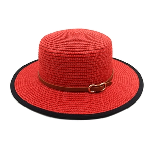 Detail of red straw flat top hat with black brim edging and horsebit leather band