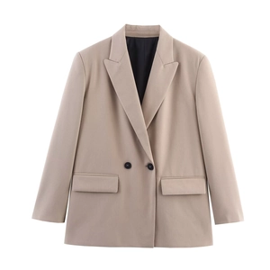 Detailed close-up of double-breasted beige blazer showing lapels and flap pockets