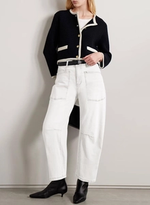 Detail of high-waist white cargo jeans with large patch pockets and clean stitching