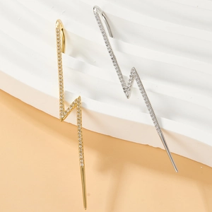 Macro shot of gold and silver lightning bolt ear cuffs with sparkling micro-pave zirconia