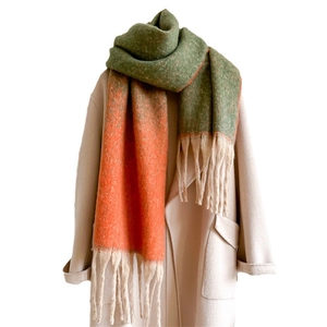 Thick gradient color scarf with fringe tassels draped on a beige coat for winter