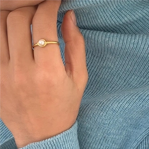 Minimalist 925 silver ring with white pearl on gold thin band worn by a model