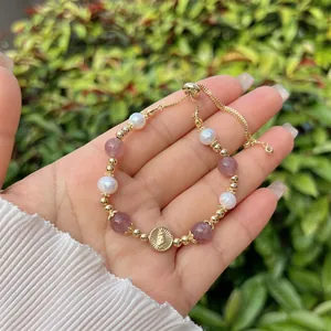 Macro detail of adjustable beaded bracelet with gold Virgin Mary medal and natural stones