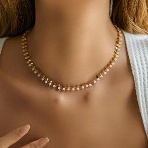 Detail of bohemian gold collar necklace featuring pink beads and small round sequins