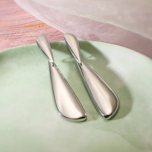 Macro detail of silver-plated teardrop earrings with a sleek mirror-polished finish