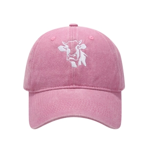 Detail of pink washed cotton denim baseball cap with white cow embroidery on the front