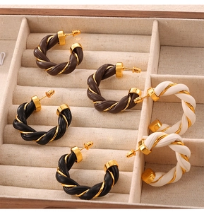 Detailed view of C-shaped hoop earrings in black, brown and beige leather twist design