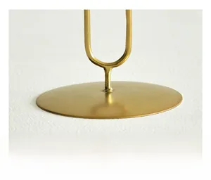 Detail of the stable golden metal round base and U-shaped stand for Nordic candle holder