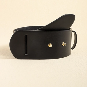Detail of a black wide leather belt with gold metal studs and a narrow buckle slot