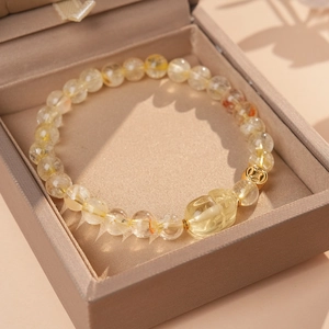 Close-up of golden citrine beaded bracelet with Pi Xiu charm in a jewelry box