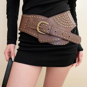 Close-up of vintage brown leather waist belt with bronze studs on a black dress