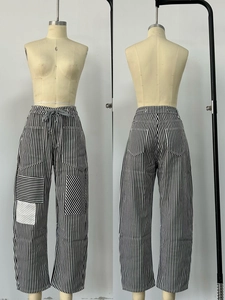 Detail of patchwork striped wide leg pants featuring drawstring waist and cargo pockets