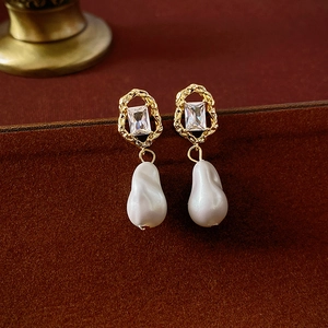 Detailed close-up of vintage baroque pearl earrings with gold plating and zircon crystals