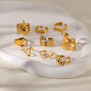 Set of 9 gold stainless steel rings with starfish shell and wave patterns on stone