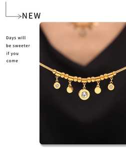 Détail du collier chaîne serpent dorée avec pendentif chiffres romains et zircons