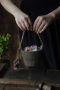 Christmas diamond painting keychain set shown in a rustic garden bucket held by hands